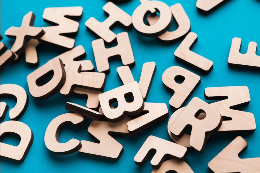 scattered letters of stock trading abbreviations on a table