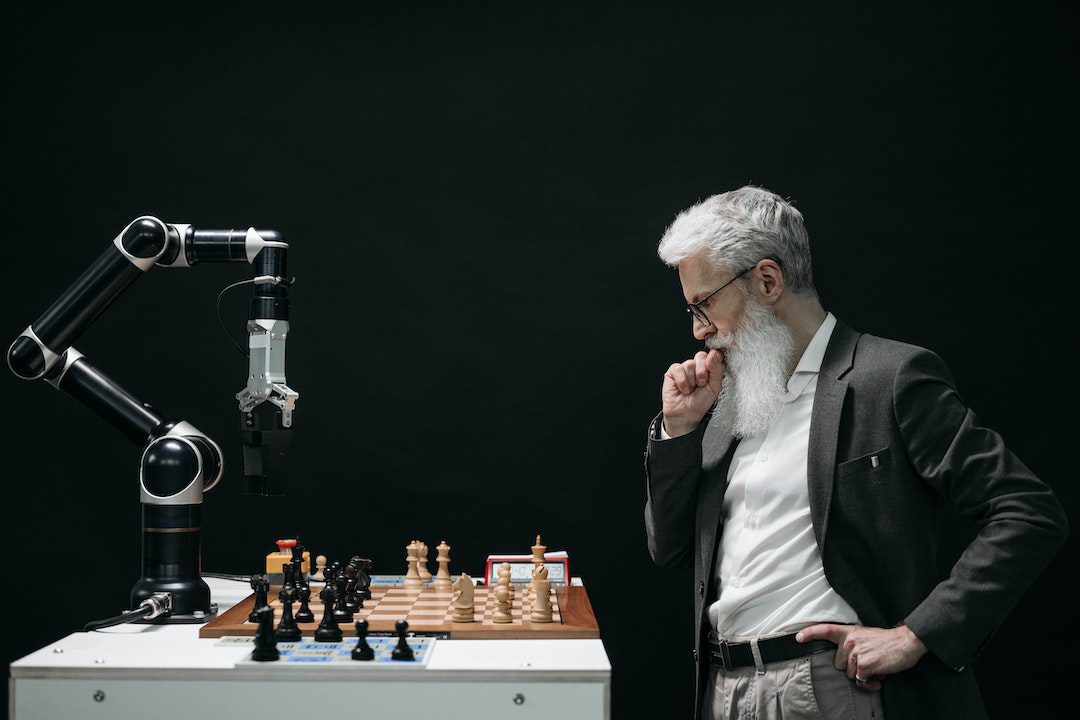 A Man Playing A Chess Game With A robot