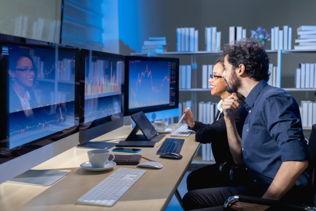 Man and women looking at stock market charts
